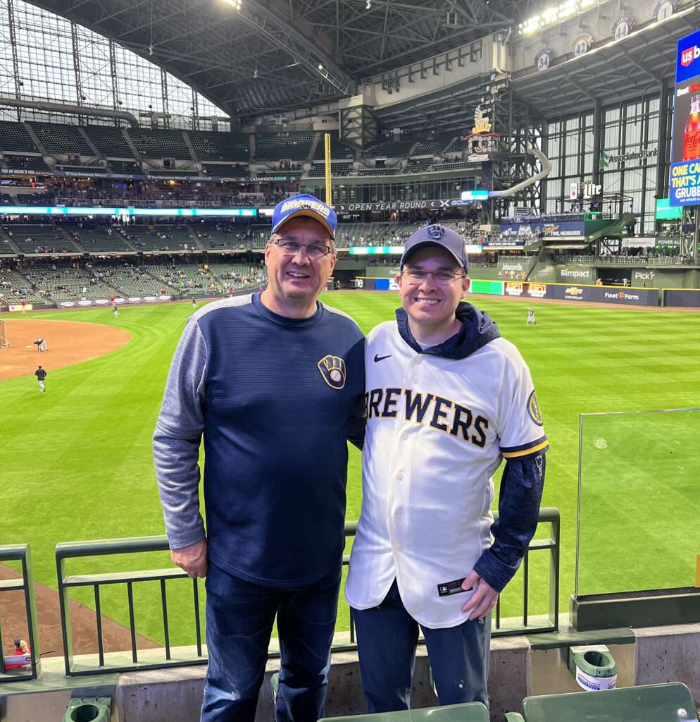 Two men in front of a baseball stadium