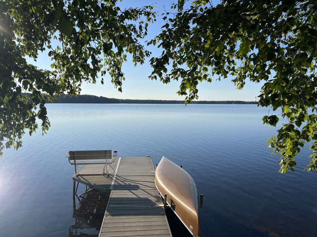 A canoe by a dock on a lake